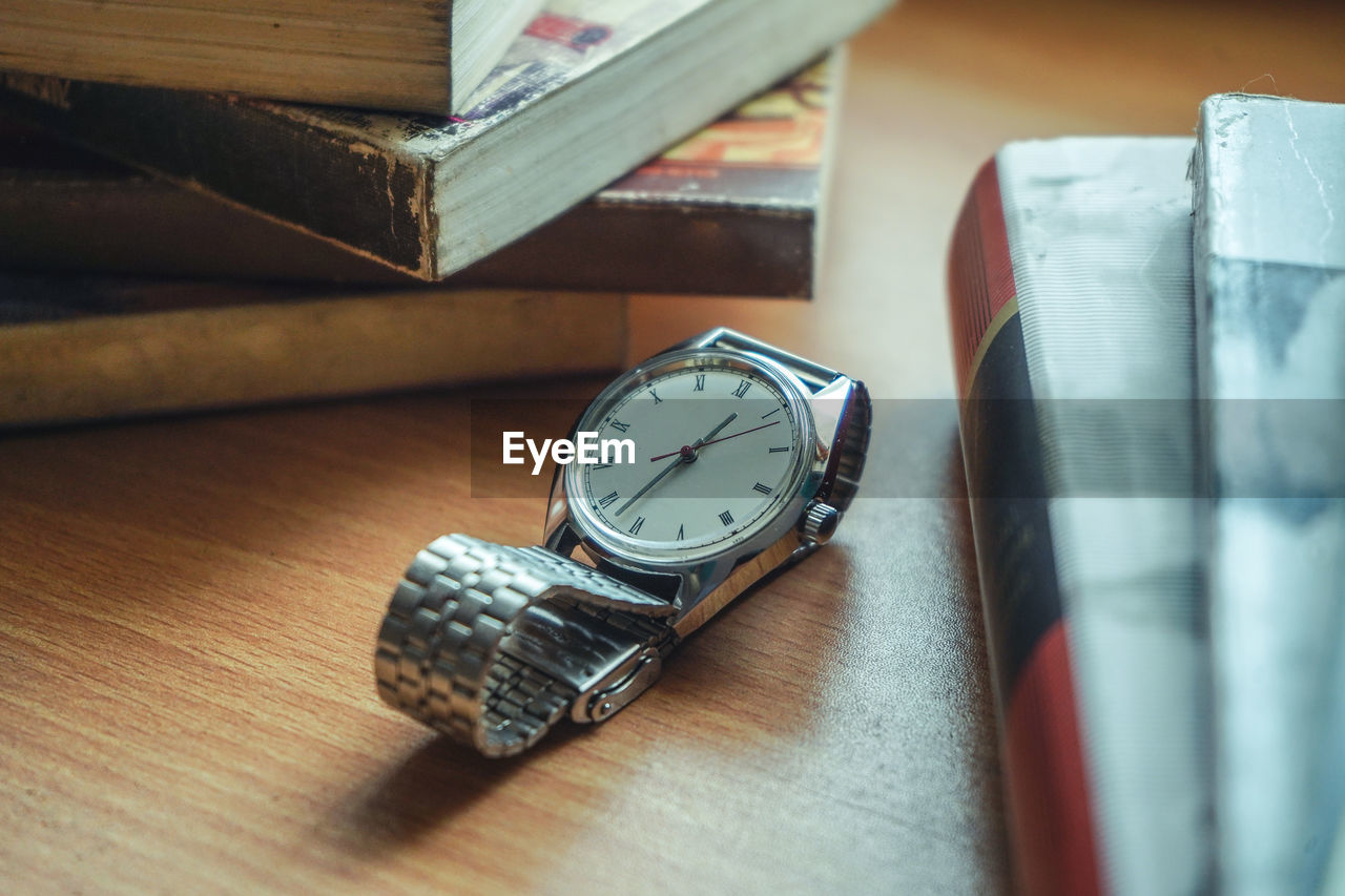 Old vintage watch and some books on a table