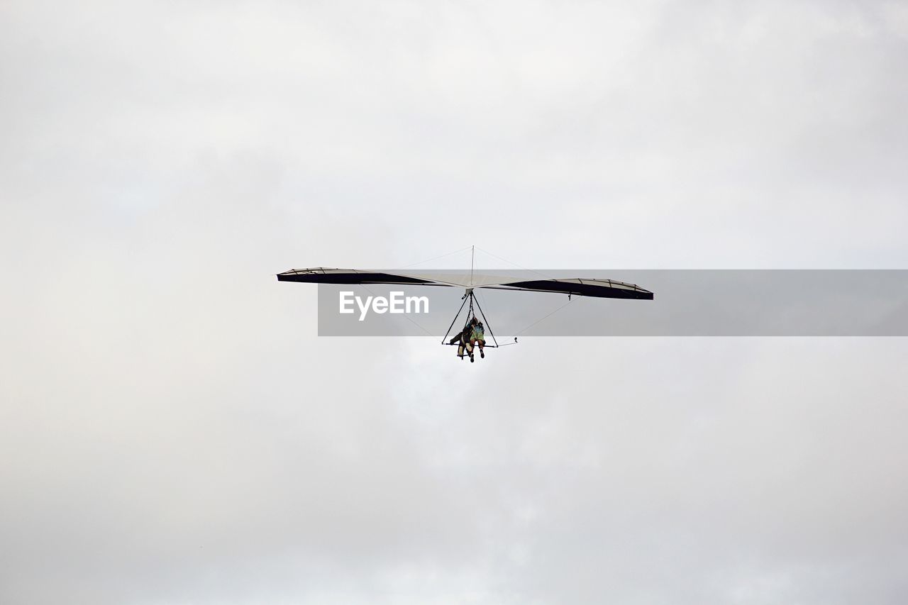 Low angle view of air vehicle flying in cloudy sky