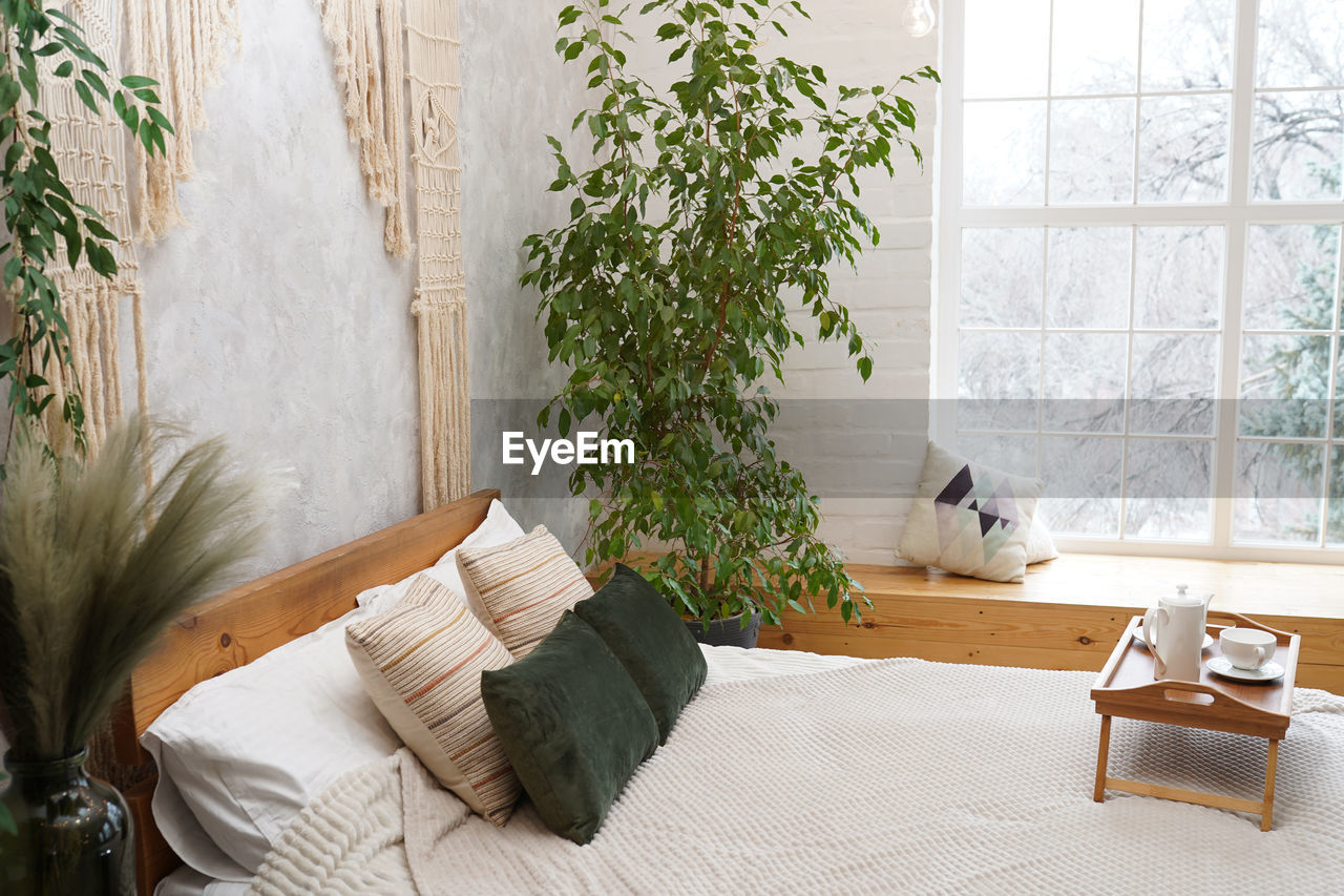 Still life details in home interior of light bedroom in bohemian chic style. breakfast on the bed