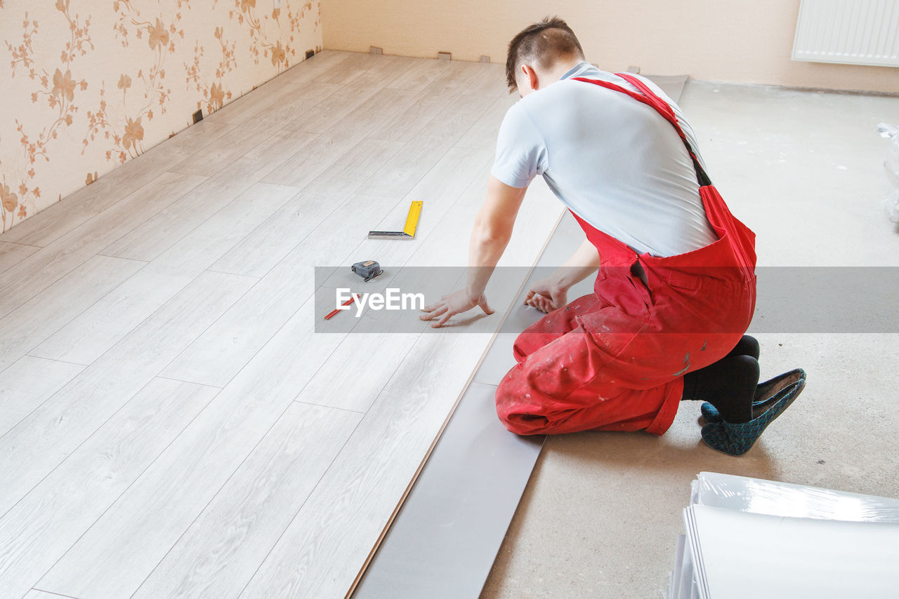 Side view of carpenter working on floor at home