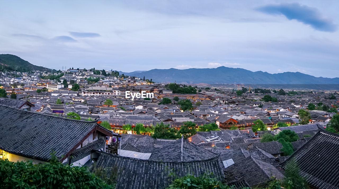 HIGH ANGLE VIEW OF TOWNSCAPE AND MOUNTAINS AGAINST SKY