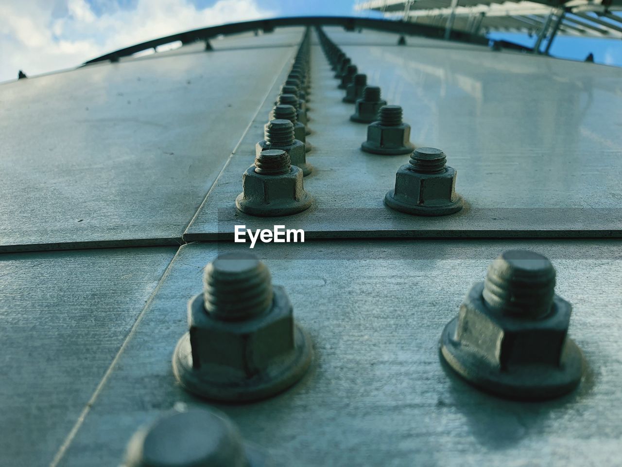 High angle view of metal water tank , rows of metal nuts and bolts