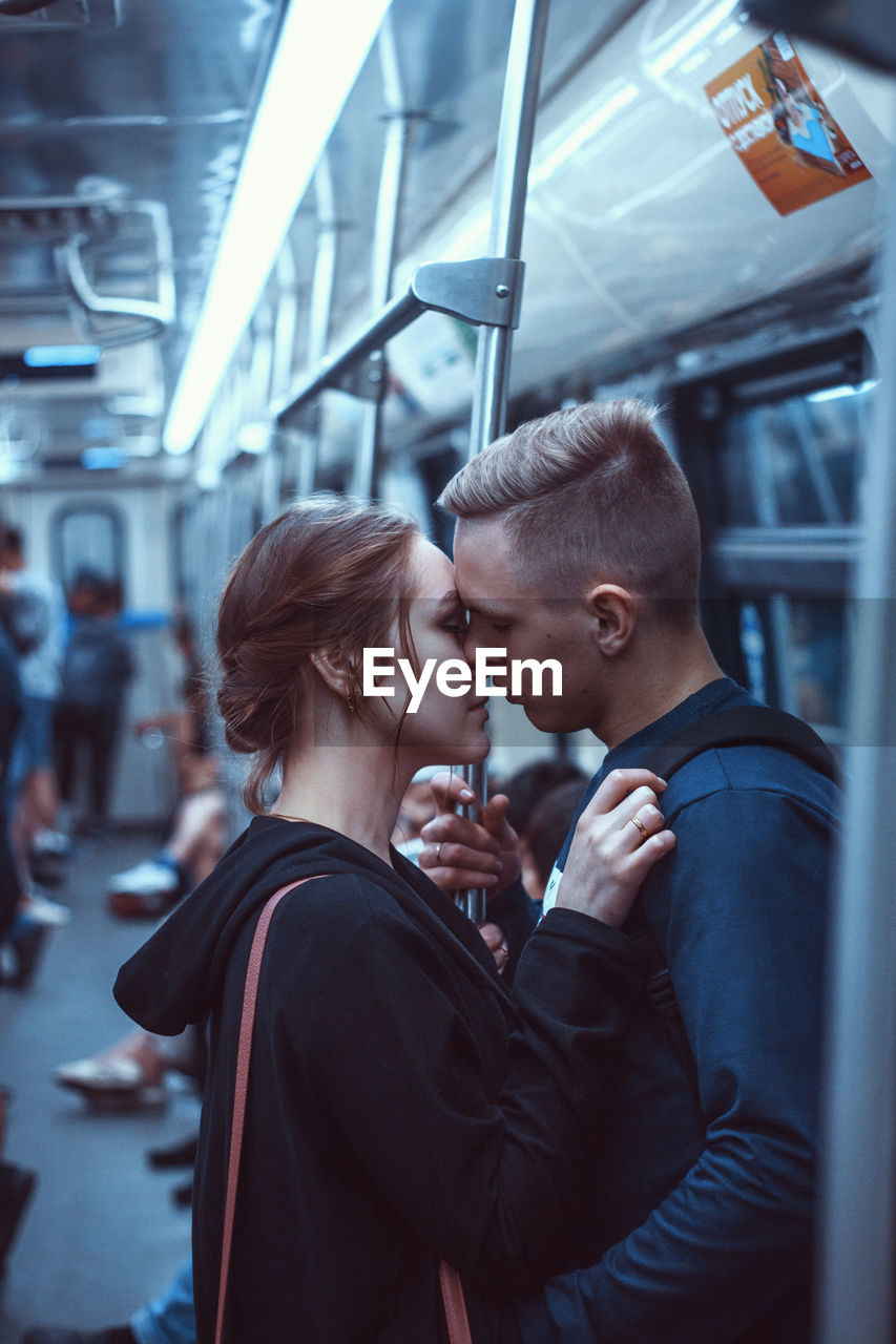 Side view of couple kissing in train