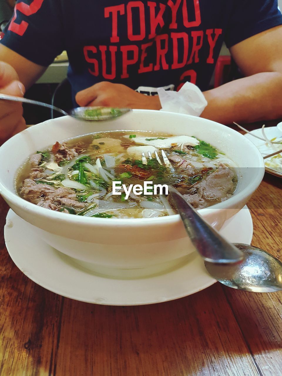 MIDSECTION OF WOMAN EATING FOOD IN PLATE