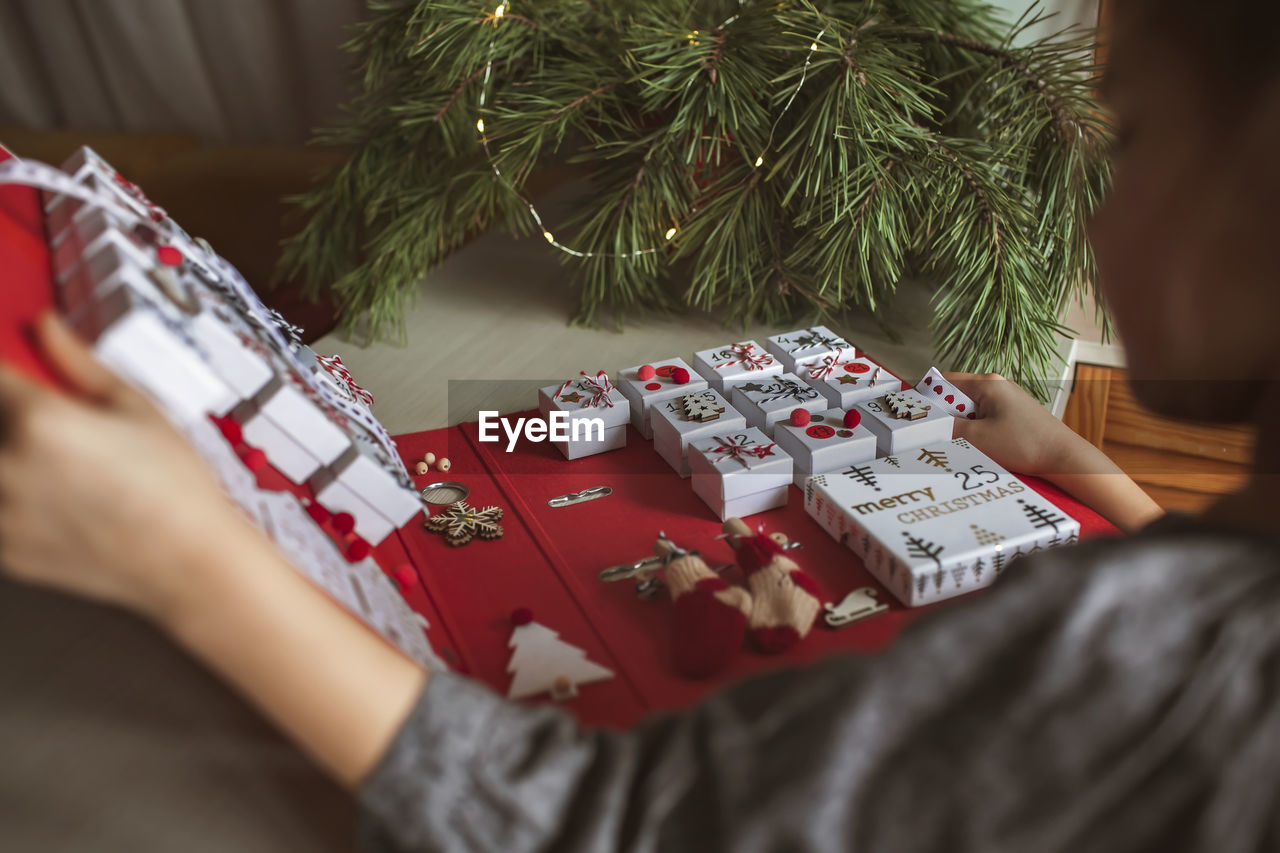 Midsection of girl opening christmas gift at home