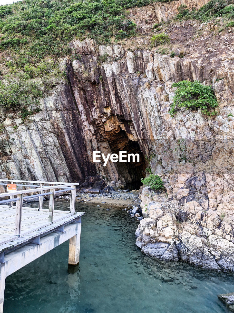 water, rock, nature, beauty in nature, rock formation, scenics - nature, no people, day, land, cliff, non-urban scene, tranquility, tranquil scene, outdoors, plant, environment, river, terrain, tree, architecture, mountain, travel destinations, geology, idyllic, coast, bridge, built structure, travel, high angle view, cave