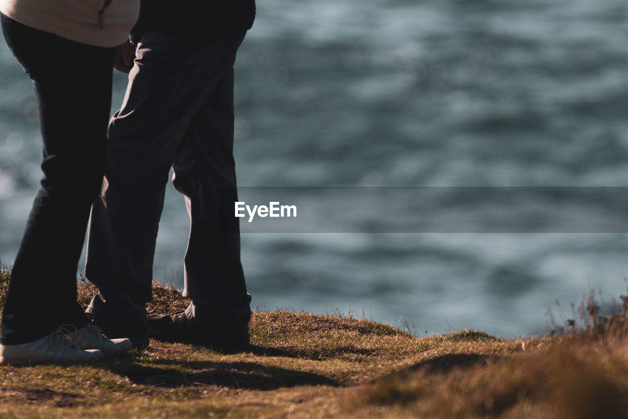 Low section of couple standing on beach