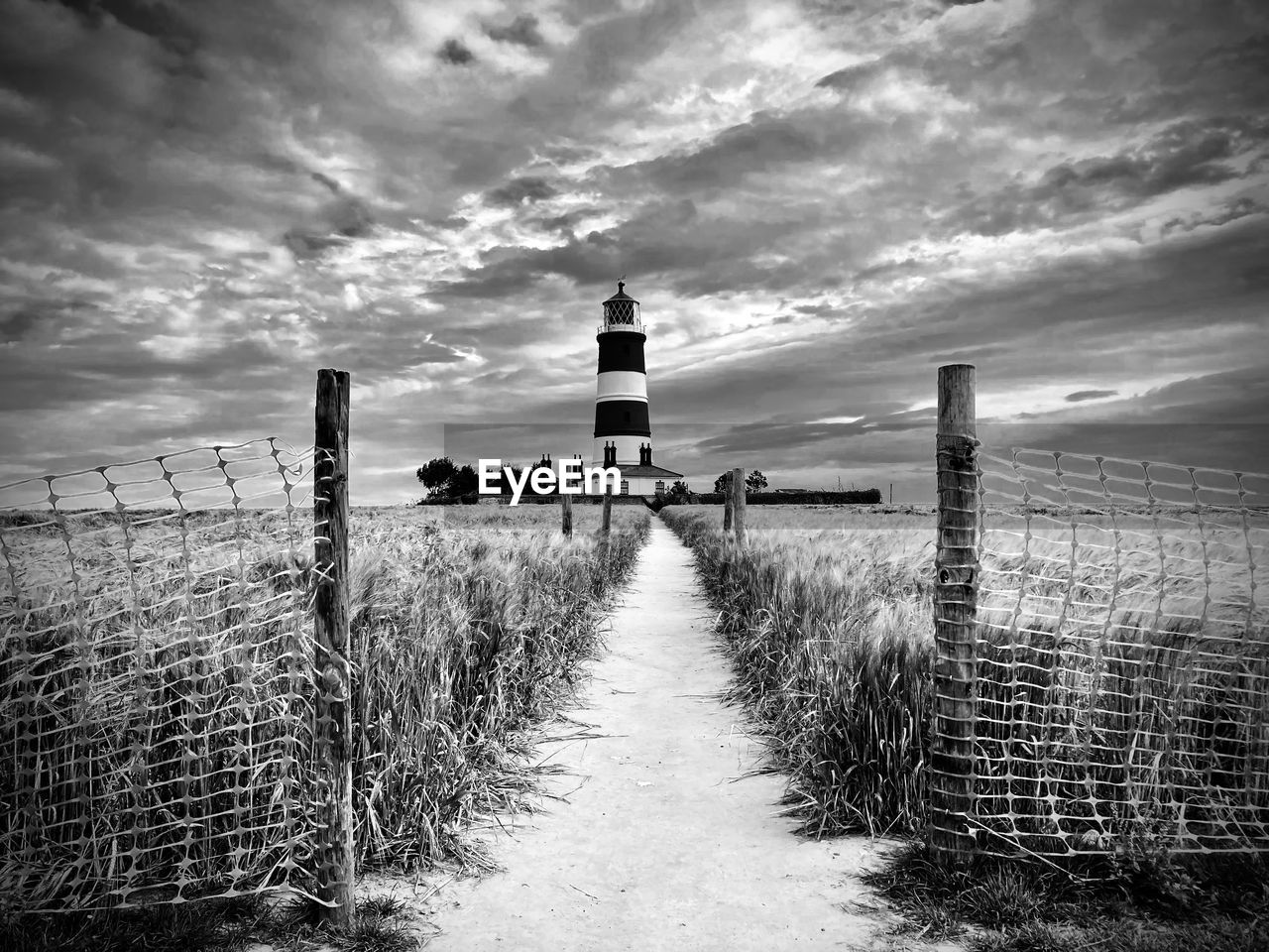 VIEW OF LIGHTHOUSE AMIDST LAND AGAINST SKY