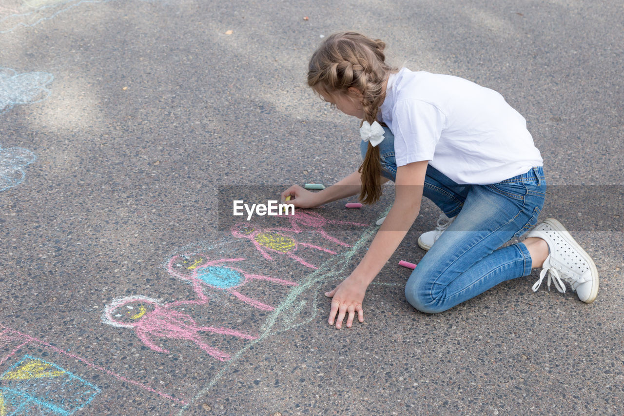 HIGH ANGLE VIEW OF GIRL PLAYING ON STONE