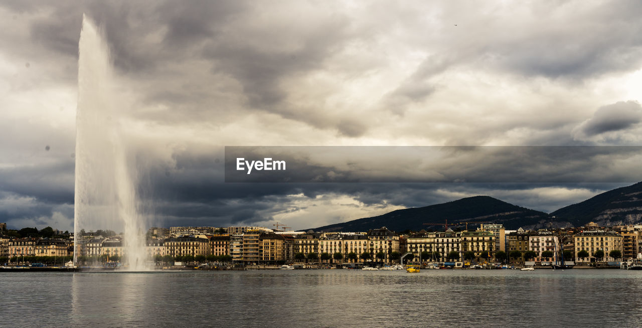 Buildings by river against sky in geneva 