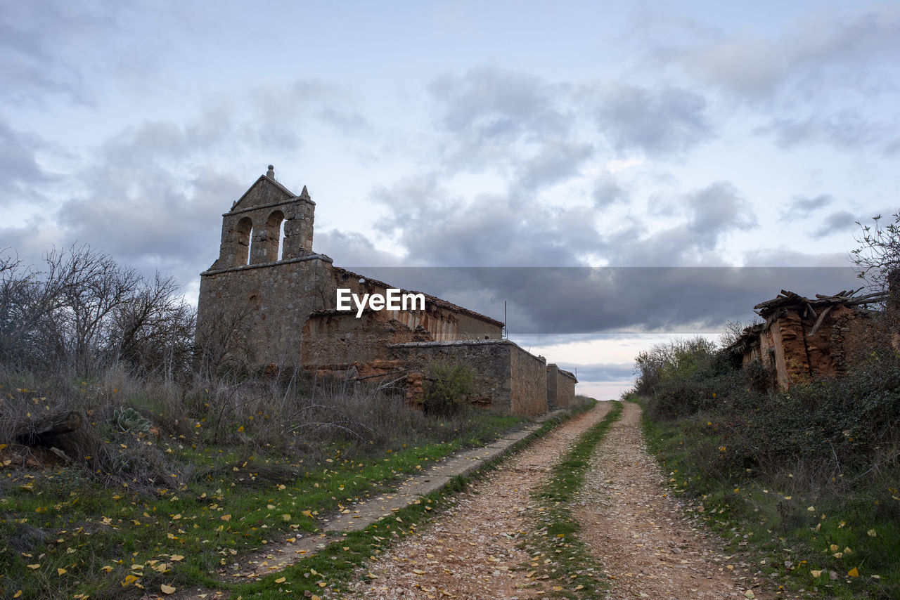 VIEW OF OLD BUILDING ON FIELD AGAINST SKY