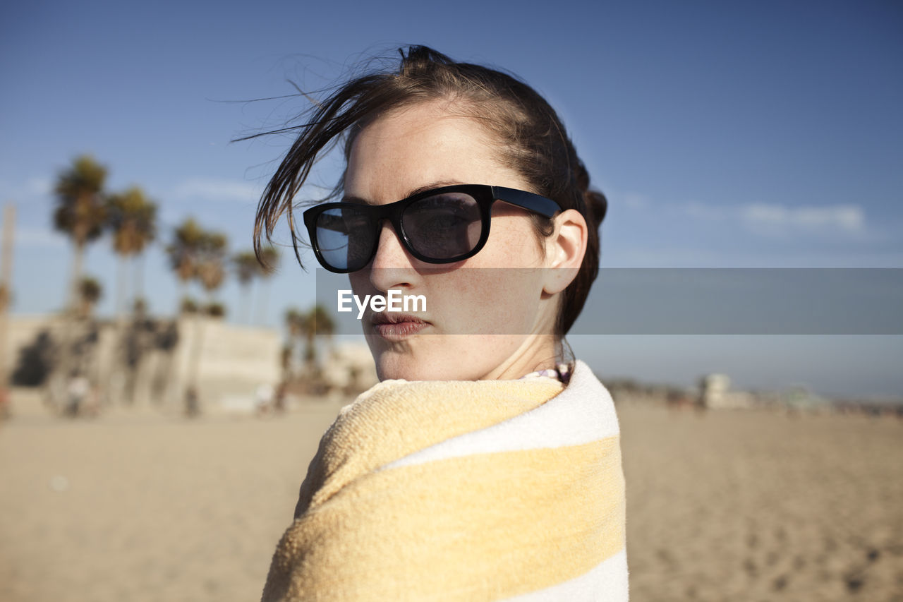 Portrait of young woman wrapped in towel on beach