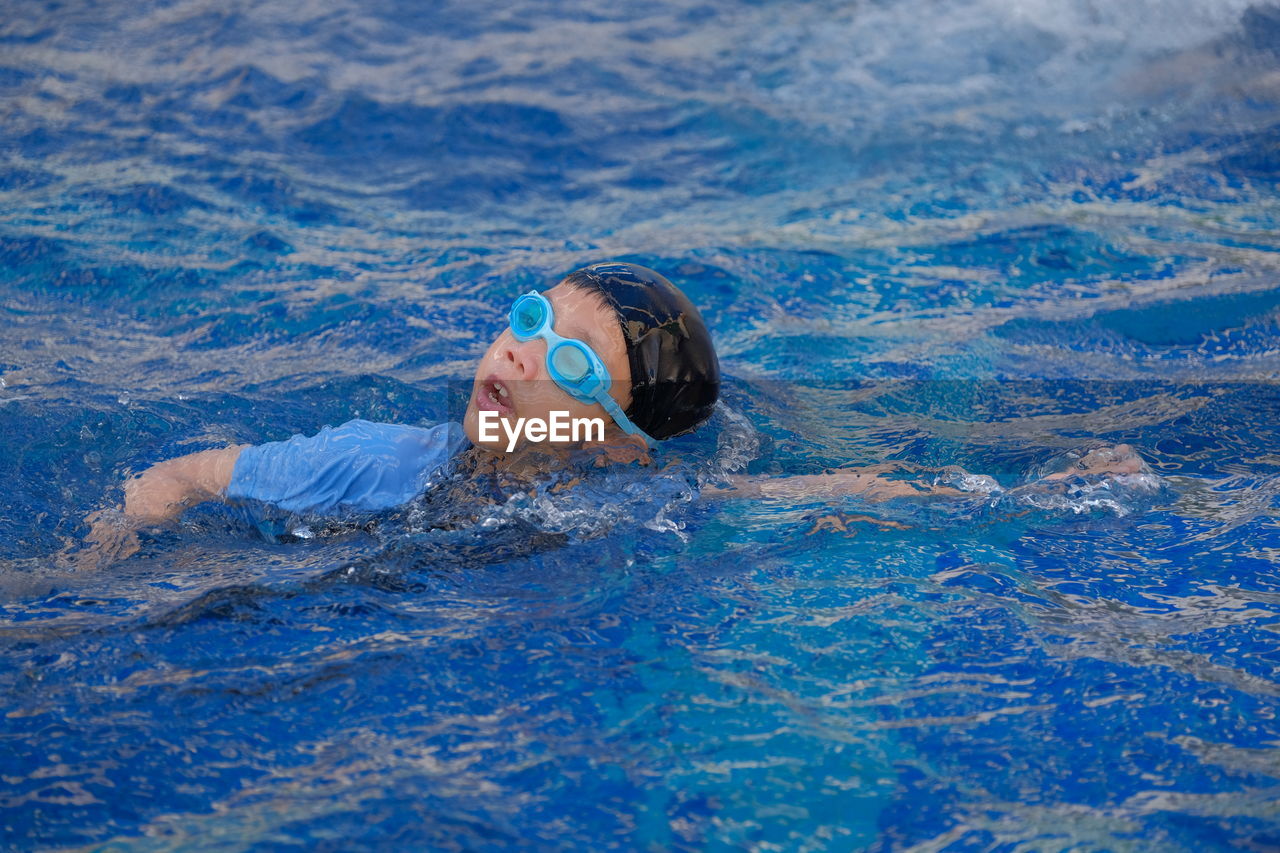 Cute boy swimming in pool