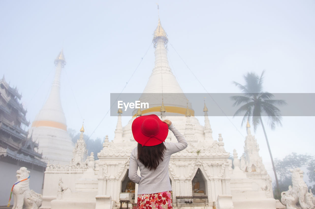 A young women tourist  visit wat phra that doi kong mu on a foggy day, mae hong son, thailand.