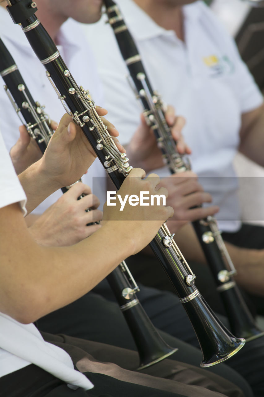 Midsection of people playing flute
