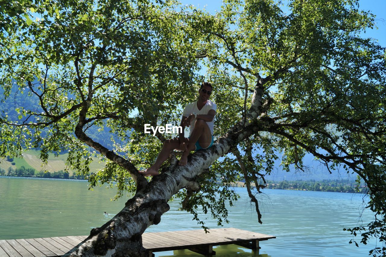 View of man on tree by river