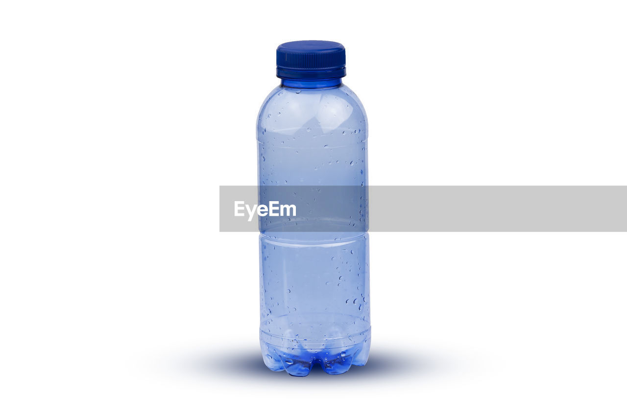 CLOSE-UP OF BOTTLE AGAINST BLUE BACKGROUND