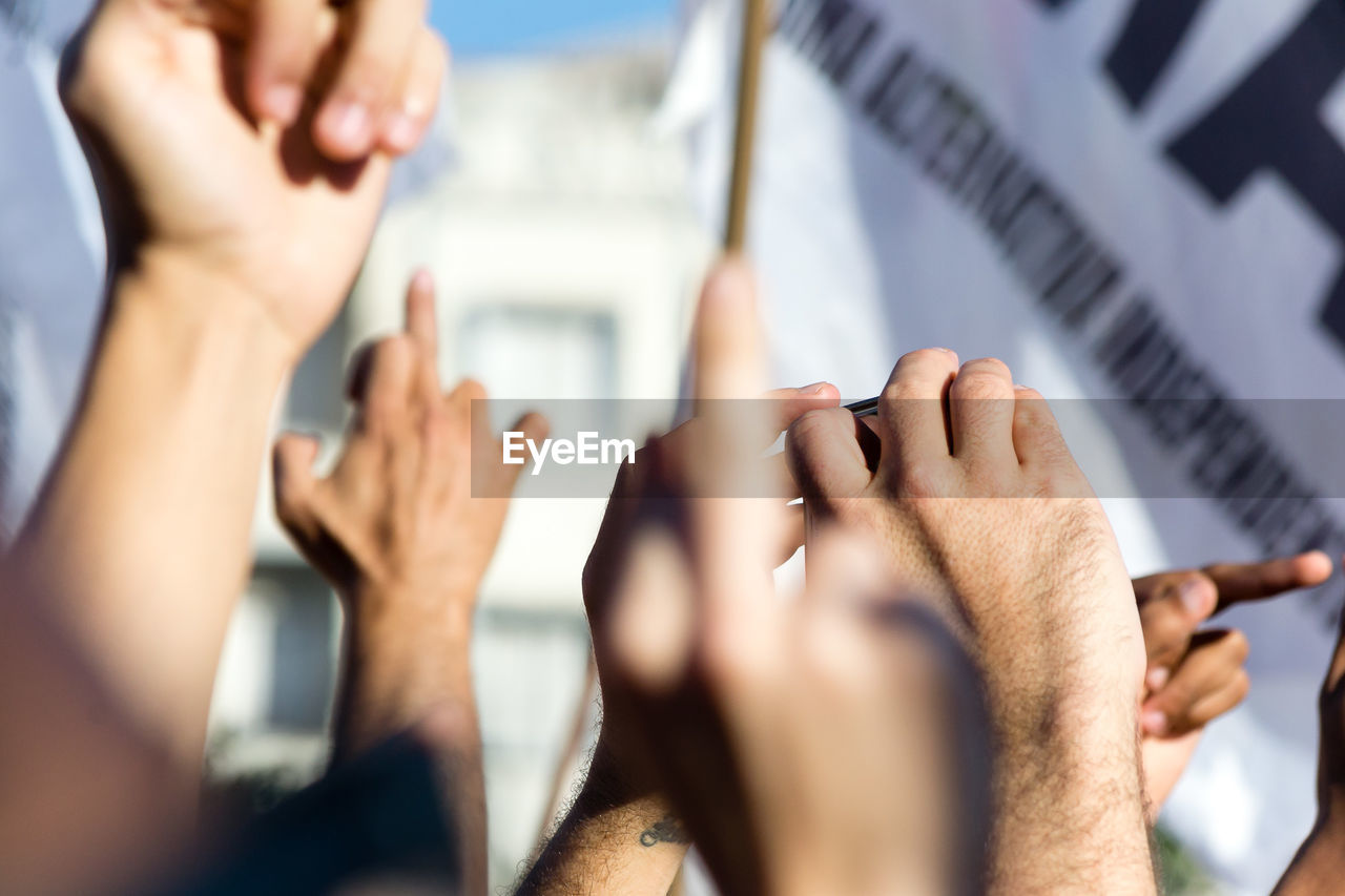 Close-up of raised hands outdoors