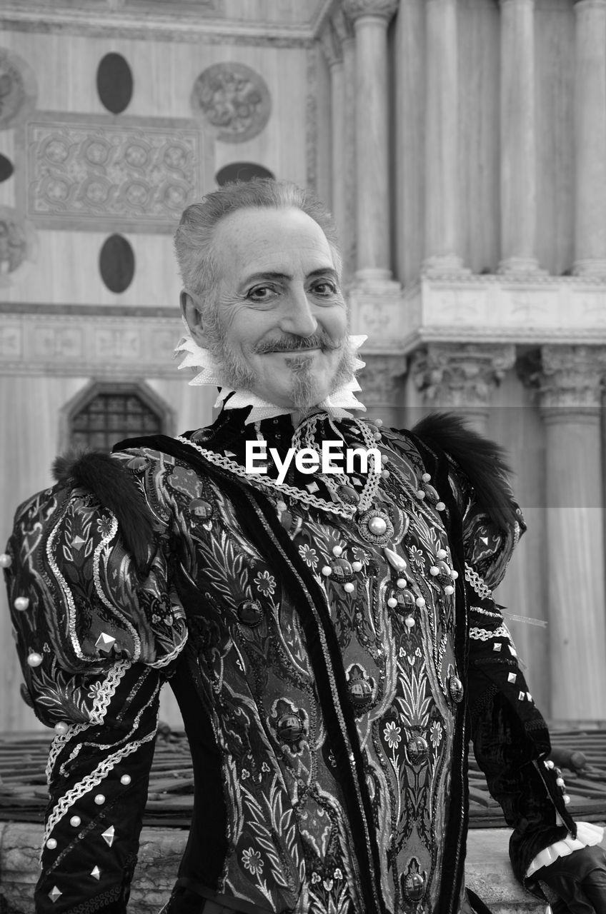 Portrait of smiling man wearing costume standing in city