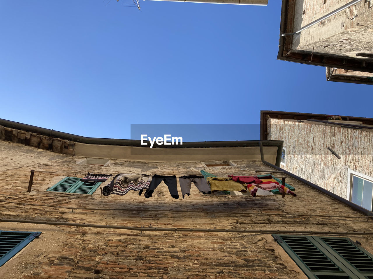 LOW ANGLE VIEW OF TEXT ON BUILDING AGAINST SKY