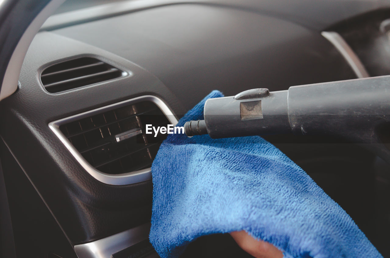 CLOSE-UP OF PERSON DRIVING CAR IN BLUE BACKGROUND