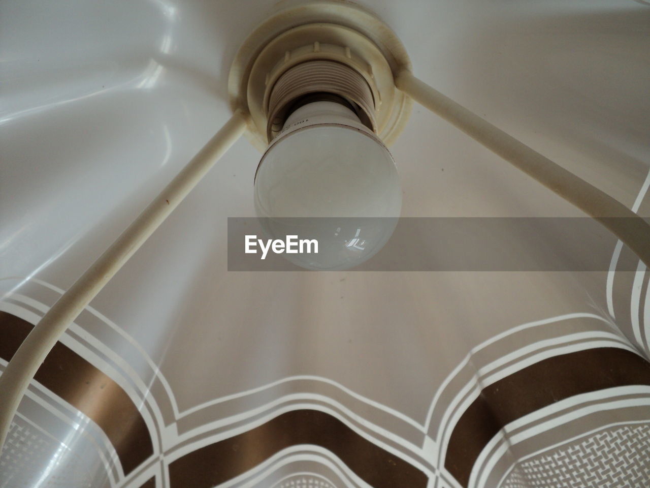 LOW ANGLE VIEW OF ILLUMINATED PENDANT LIGHT HANGING FROM CEILING