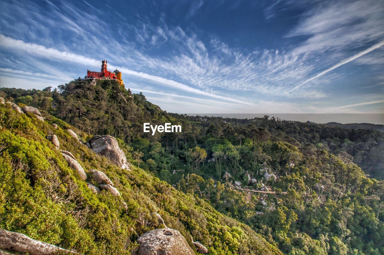 Scenic view of mountains and a colorful palace against sky 