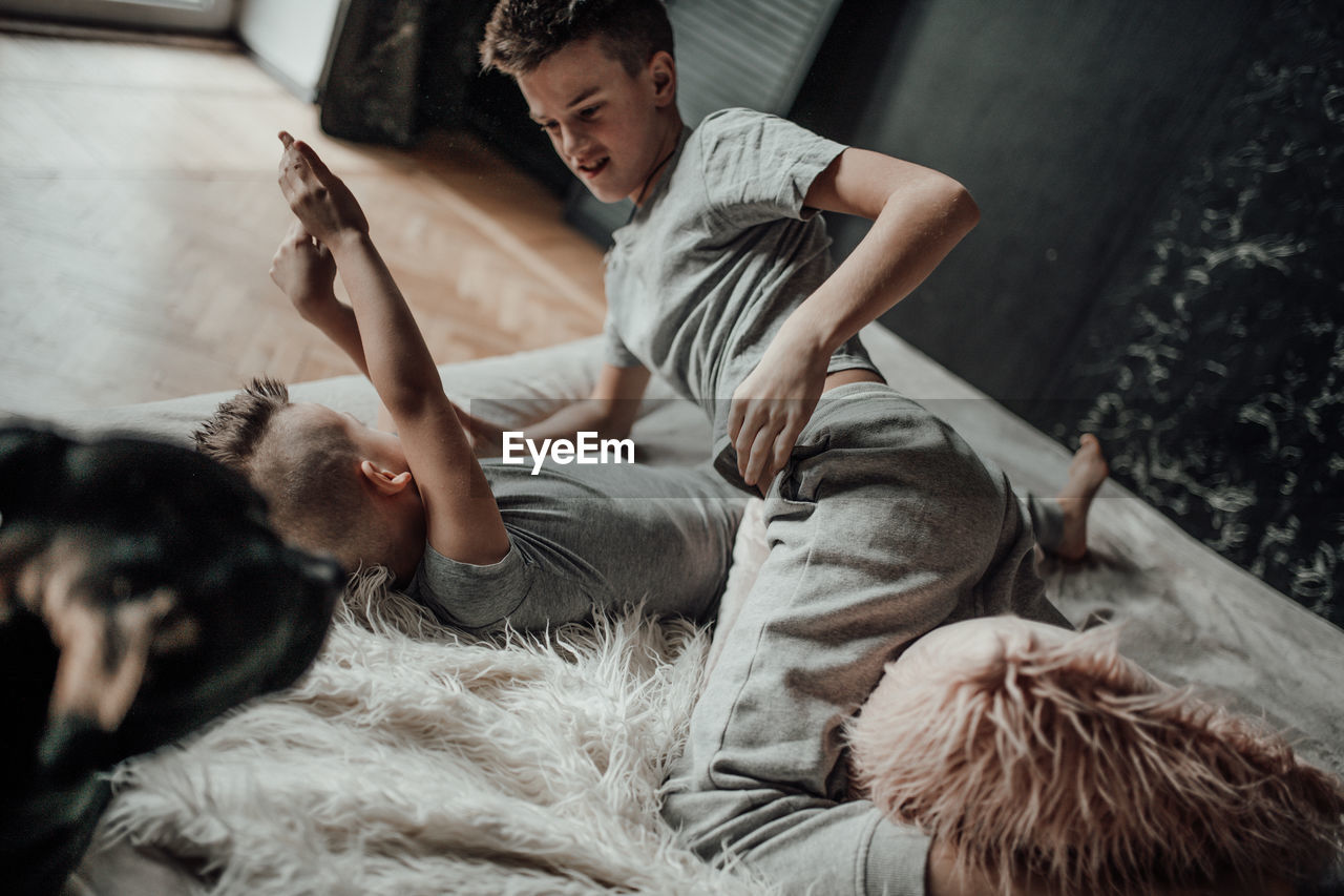 High angle view of friends lying on floor at home