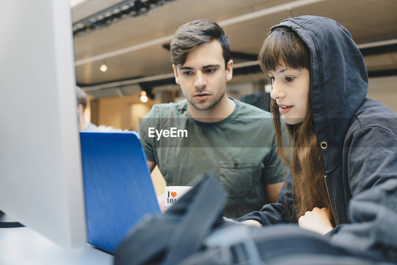 Computer programmers using laptop at office