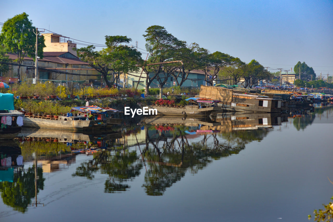 Scenic view of river by buildings against sky