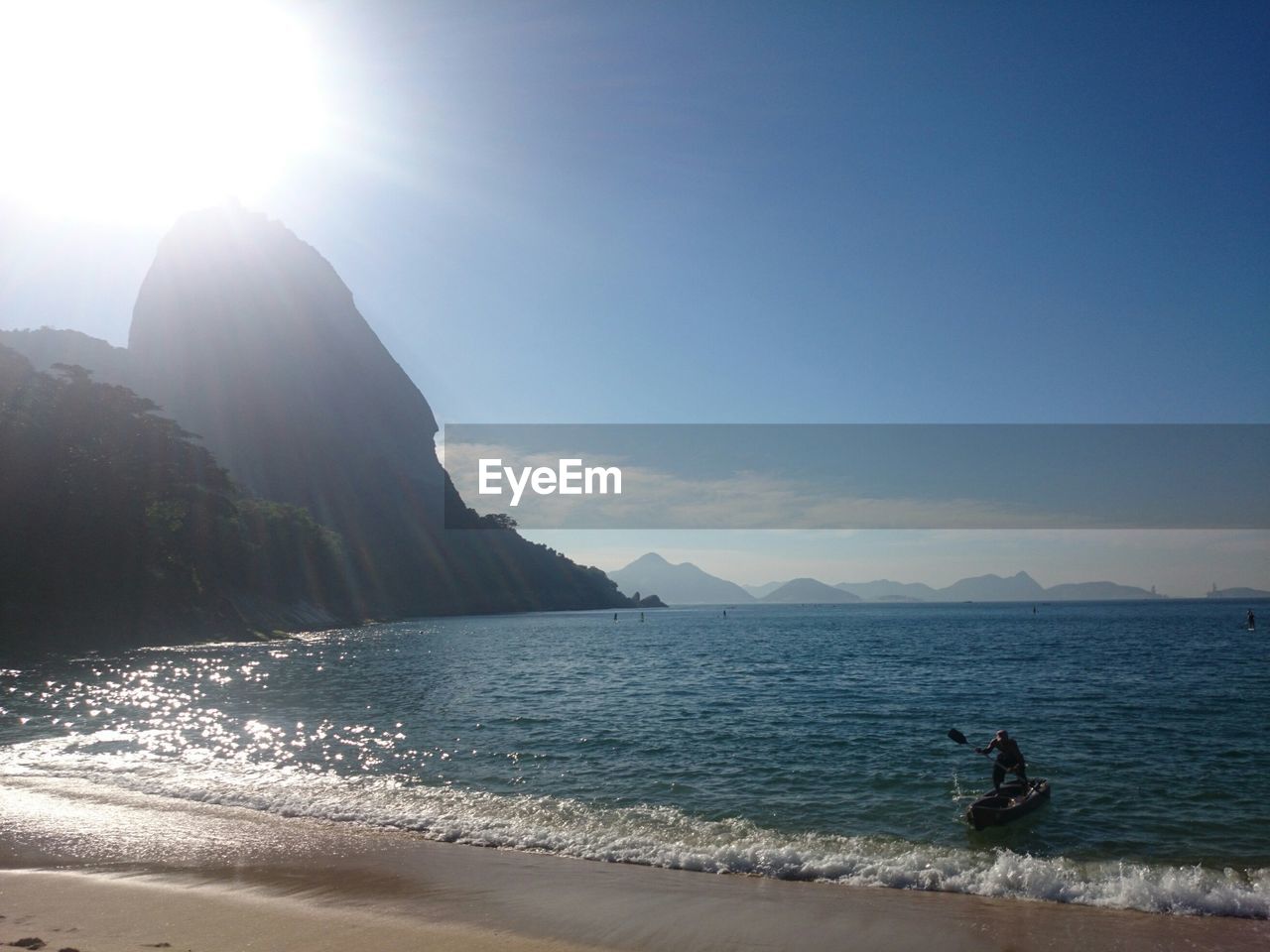 Scenic sea bay with man addling in foreground