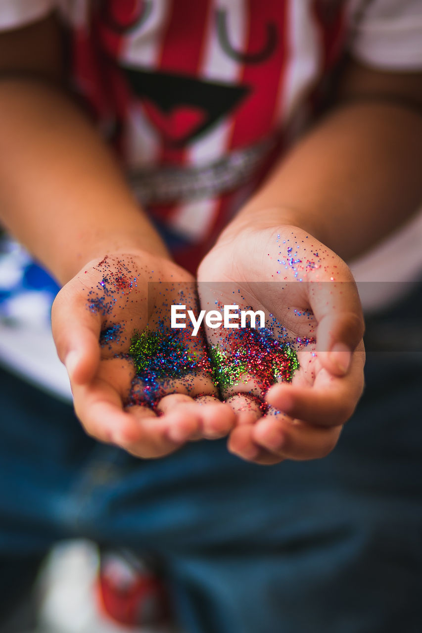 Midsection of boy holding confetti