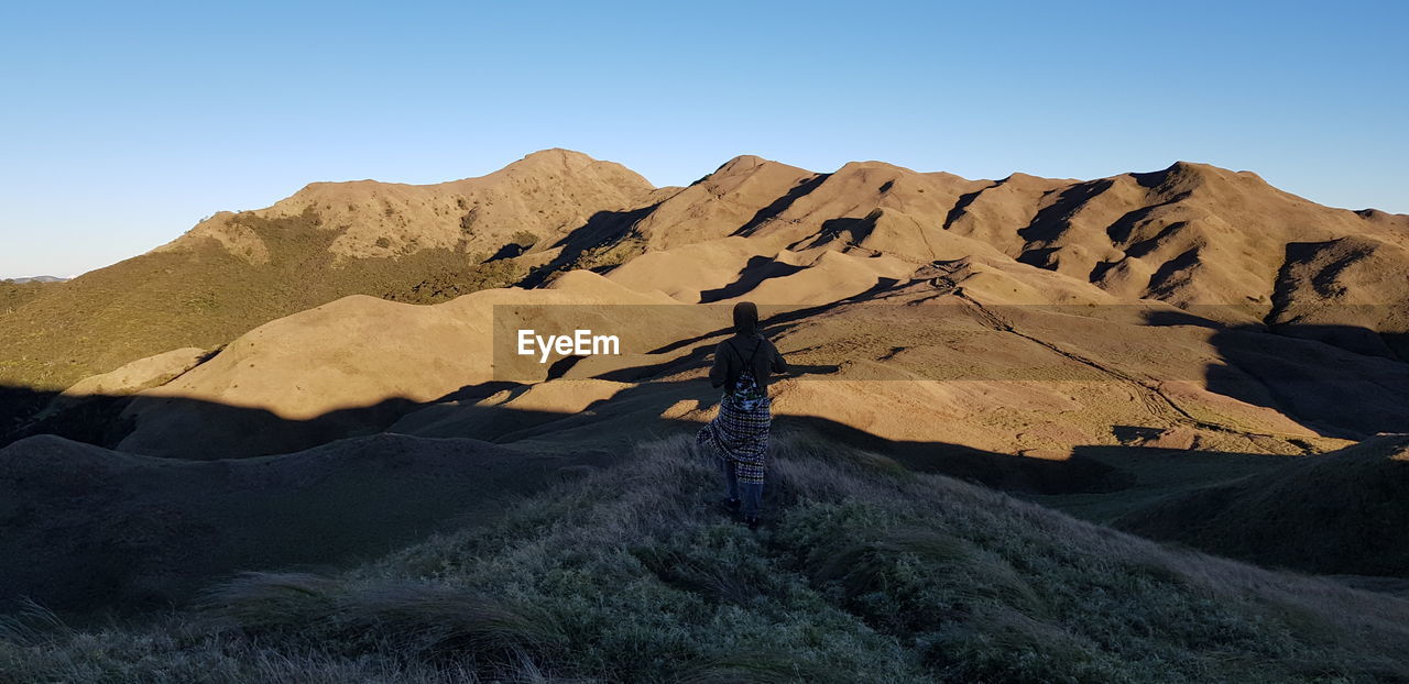 Scenic view of arid landscape against clear blue sky