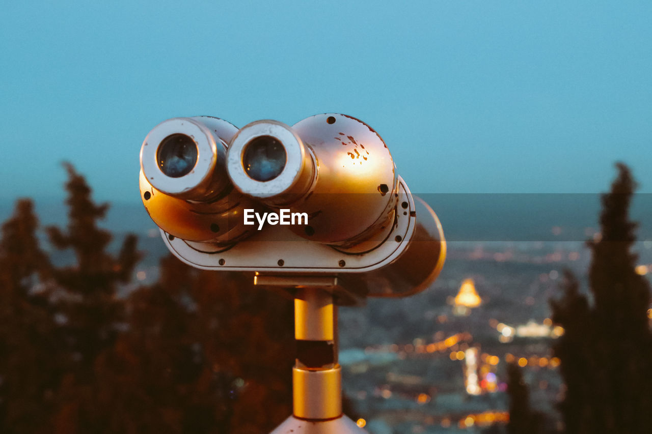 Tourist binoculars at dusk on the panorama of the city