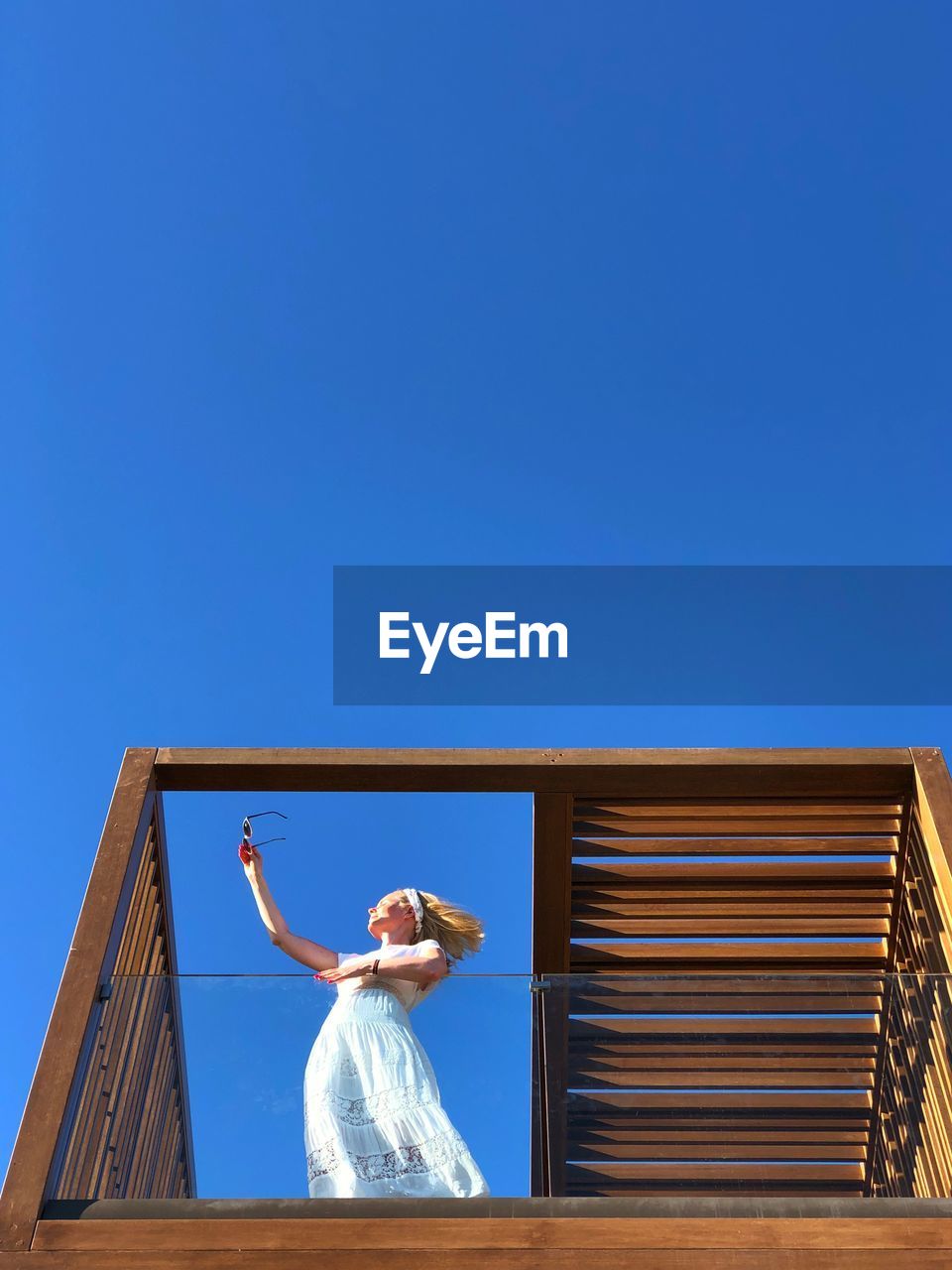 A woman in white dress against blue sky