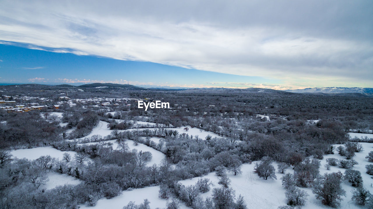 SNOW COVERED LANDSCAPE AGAINST SKY DURING WINTER