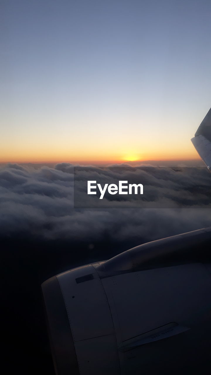 AERIAL VIEW OF AIRCRAFT WING OVER CLOUDS