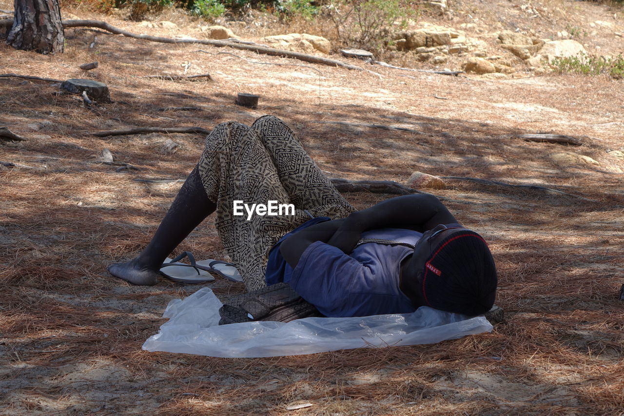 LOW SECTION OF MAN LYING DOWN ON GROUND