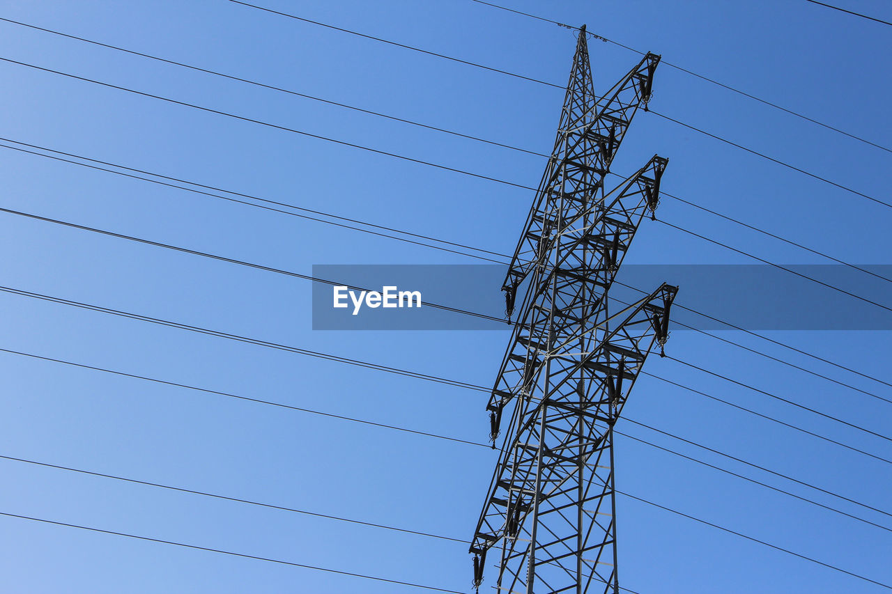 LOW ANGLE VIEW OF ELECTRICITY PYLONS AGAINST CLEAR BLUE SKY