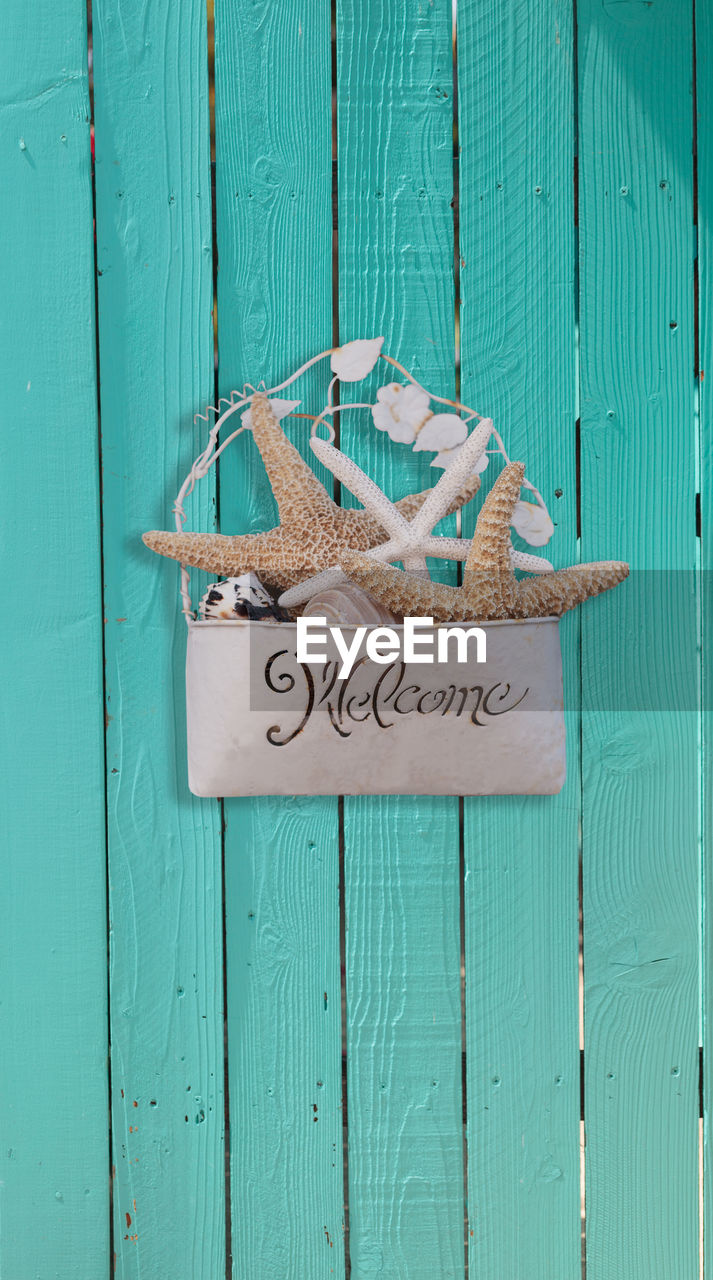 Close-up of welcome sign on wooden door