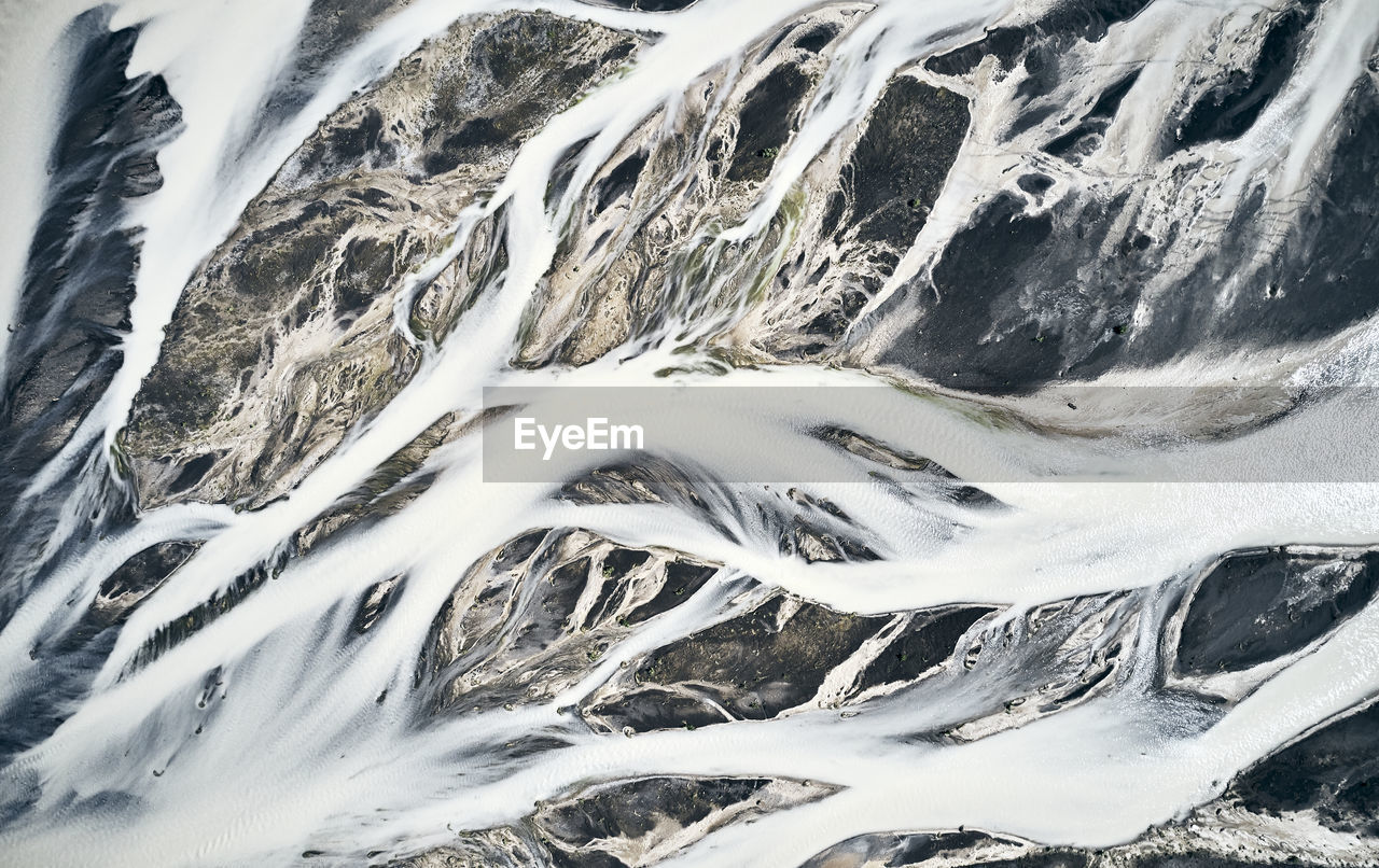 Streams of frozen snow covering mountainous land