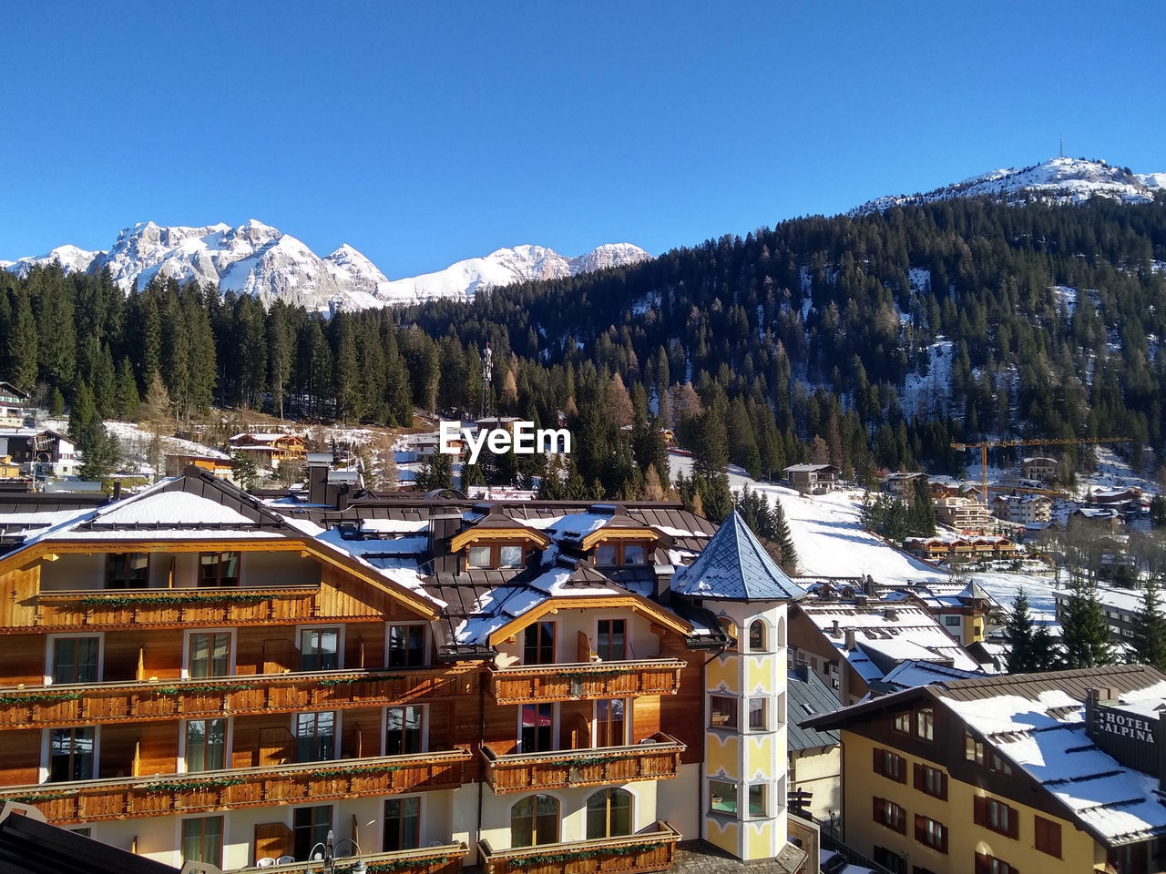 Houses on snowcapped mountain against clear sky