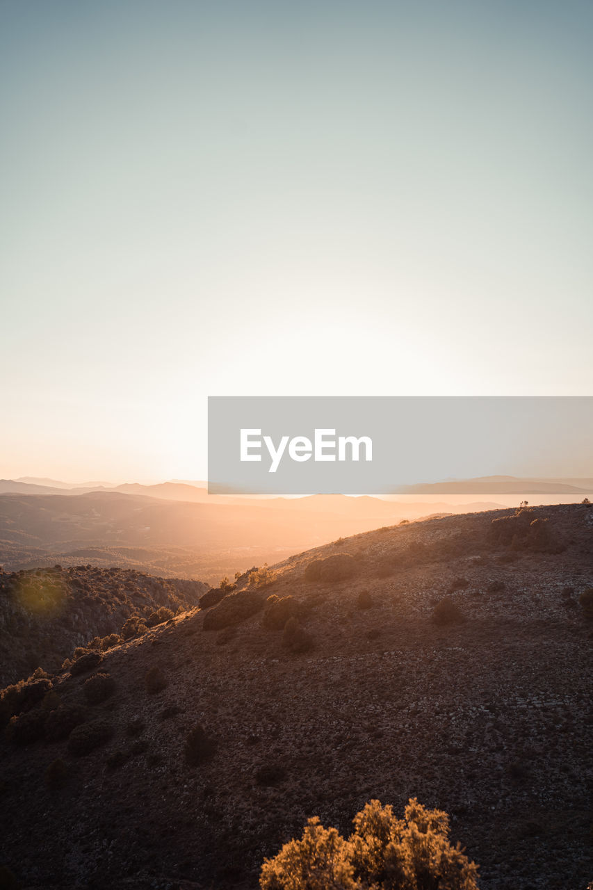 Scenic view of landscape against clear sky during sunset