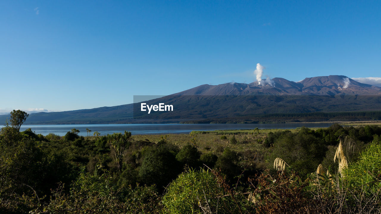 Scenic view of mountains against clear blue sky