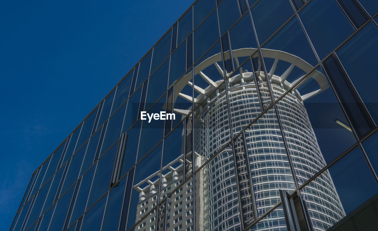 Low angle view of skyscrapers against blue sky