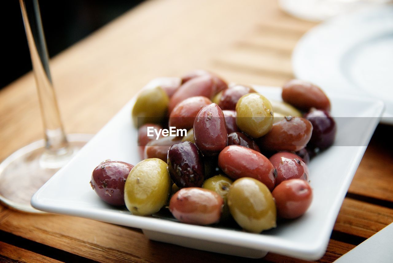 Close-up of pickled olives in tray on table