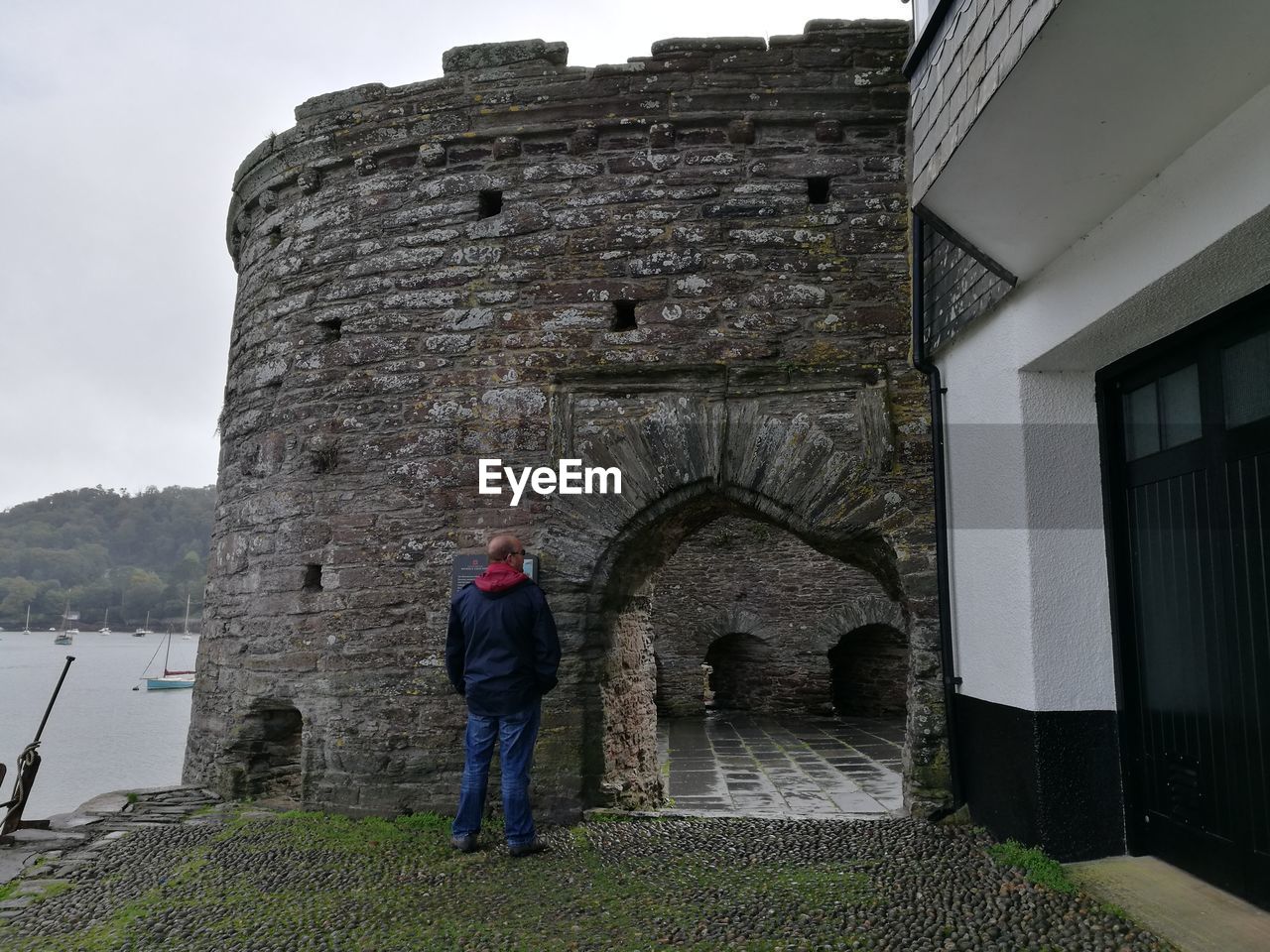 FULL LENGTH REAR VIEW OF MAN STANDING AT HISTORIC BUILDING