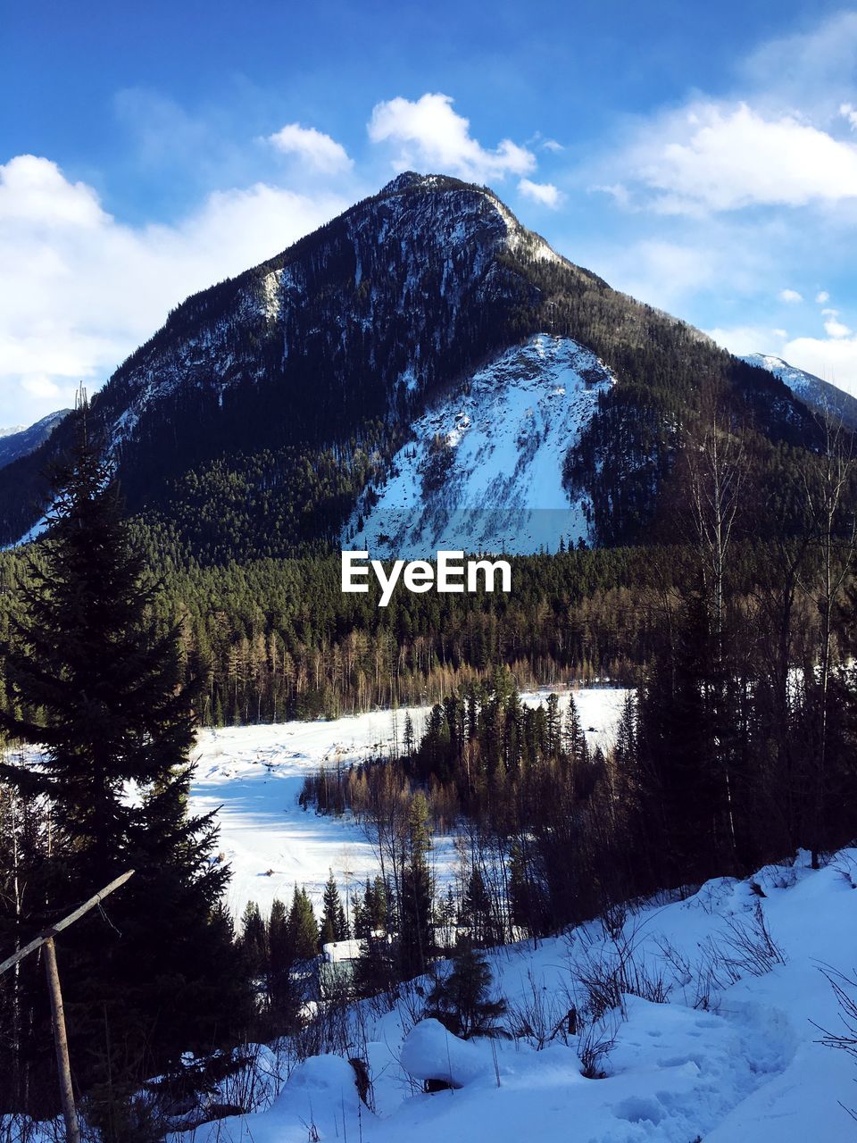 Scenic view of lake by snowcapped mountains against sky