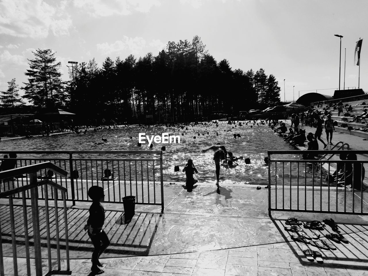 PEOPLE IN WATER AT PARK AGAINST SKY