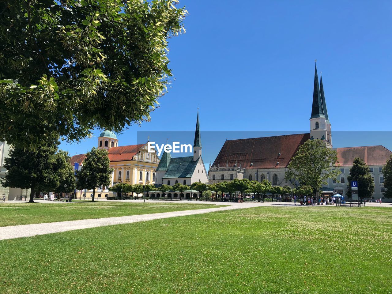 View of trees and buildings against blue sky